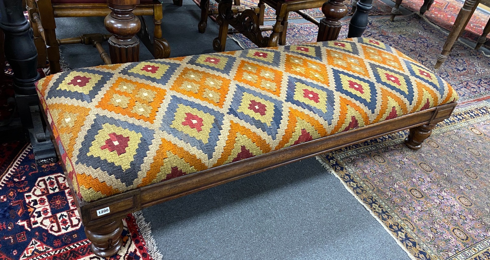 A William IV mahogany stool with polychrome kilim upholstered seat width 164cms, depth 59cms, height 36cms. (Adapted).
